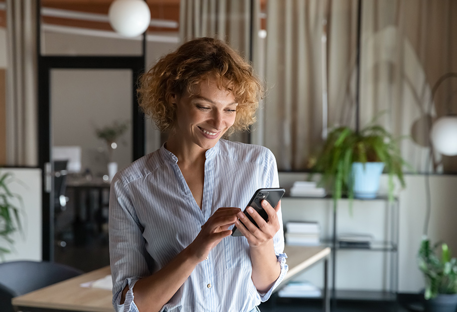 femme heureuse qui regarde son smartphone