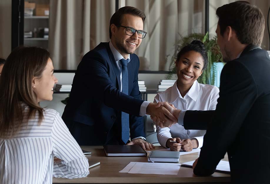 réunion avec plusieurs personnes qui se serrent la main