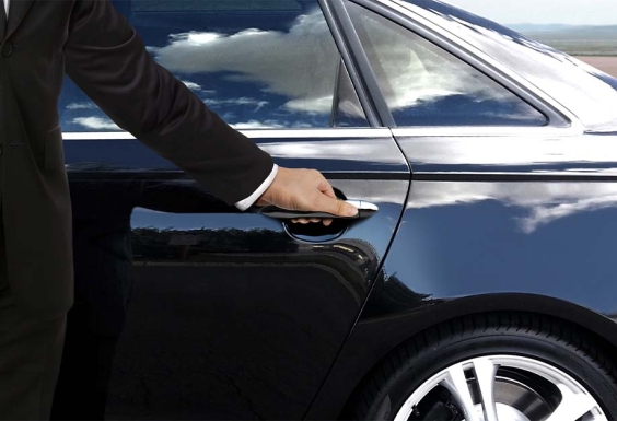 chauffeur opening the door of a limousine