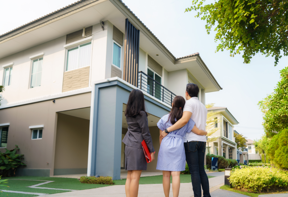 Couple avec un agent immobilier devant un immeuble