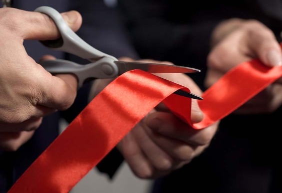 scissors cutting a red ribbon